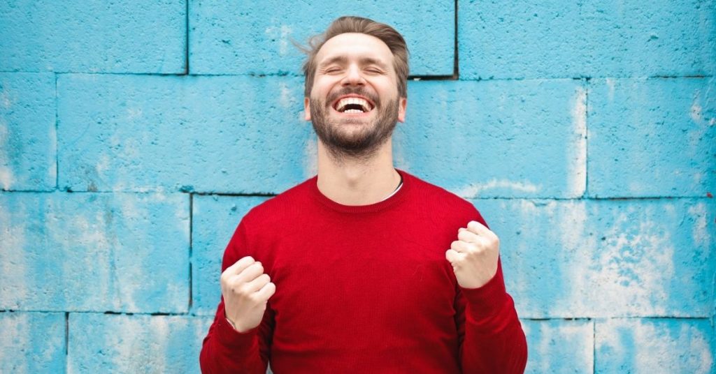 mur-bleu-homme-heureux-pull-rouge
